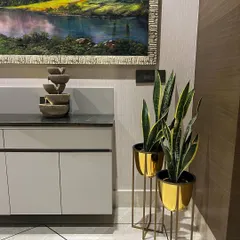 We also provide decor accents like these elegant golden metal planters. Paired with artificial snake plants, they add a touch of glamour and sophistication to this modern space.