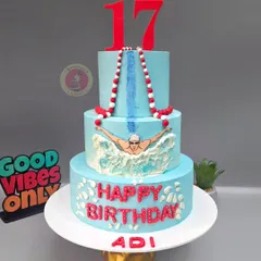 A three-tier swimming-themed cake for a champion's 17th birthday, complete with swimming lanes and a fondant swimmer in action.