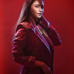 This shot captures a more pensive moment. The pose and the soft, diffused red light work together to create a portrait that feels both fashionable and narrative, as if caught in a moment of thought.
