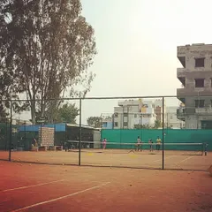 A view across multiple courts shows various training sessions happening simultaneously at the academy.