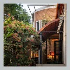 In my own home, the architecture is designed to embrace the landscape. A curved roof extends over an outdoor seating area, while lush flowering vines grow up and around the structure, making the garden a part of the house itself.