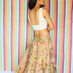 This summer-perfect outfit combines a light, floral organza skirt with a custom white chikankari blouse featuring a deep, elegant back. It’s a fresh and retro-inspired look for any daytime celebration.