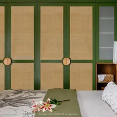 In the 'Cover me in Sunshine' master bedroom, we designed this wardrobe with green and rattan panels and custom circular wooden handles, continuing the room's earthy, serene character.