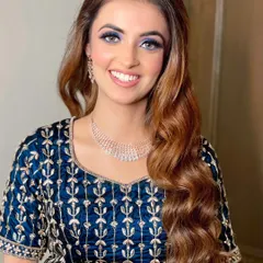 A close-up of this bold and beautiful reception look. The vibrant blue eyeshadow makes her eyes pop, balanced with a dewy base and a soft pink lip for a striking finish.