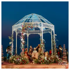 A stunning glass gazebo mandap set against the twilight sky in Goa. We adorned this modern structure with delicate florals to create a romantic and elegant ceremony space.