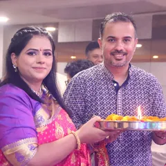 A couple participates in a traditional puja, holding a thali with flowers and a lit diya. We respectfully document the rituals and blessings of your family ceremonies.