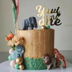 A chic safari-themed cake for a first birthday. I used a gold art-deco stencil and a rustic green texture, then added cute animal figures and dried wheat stalks for a modern, bohemian take on a classic theme.