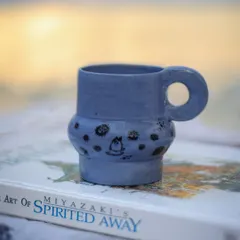 For the love of Ghibli, this mug is for you. I created this unique periwinkle blue clay by adding cobalt and iron oxide, then hand-painted my favorite soot sprites. This piece is a perfect example of the custom, whimsical commissions I love to create.