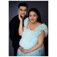 An intimate couple's maternity portrait. The father-to-be embraces his partner, creating a beautiful image of shared excitement and love.