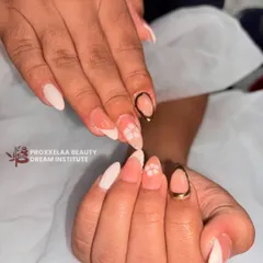 A minimalist and elegant design on almond-shaped nails. This set combines a soft, milky white base with delicate hand-painted flowers and a modern gold-outlined accent nail.