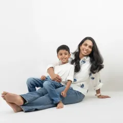 A mother and her children share a playful, loving moment against a clean, white background. This minimalist style allows their genuine emotions to be the focus of the photograph.