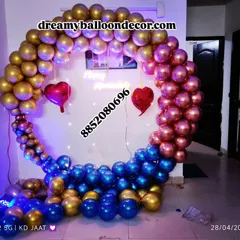 A bold and stylish balloon ring decoration. The mix of metallic gold, blue, and chrome pink balloons, along with fairy lights and heart accents, creates a modern and eye-catching backdrop.