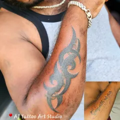 This client wanted to cover an old name tattoo on his bicep. I designed a bold tribal piece that completely concealed it.