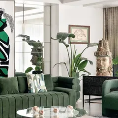 Green is a color of life and tranquility. In this living room, I used a rich green velvet sofa as the centerpiece, complemented by indoor plants and a striking stone sculpture. The mirrored wall adds depth and reflects the greenery, making the space feel larger and more open.