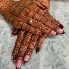 For my beautiful brides, I create nail art that complements your intricate mehndi. This design features deep maroon French tips on a natural base, with a touch of gold glitter to match the richness of your special day. It’s the perfect finishing touch for your bridal look.