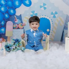Dressed in a smart blue suit, this little gentleman celebrates his first birthday. Our candy-themed setup creates a sweet and whimsical backdrop for this milestone portrait.