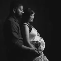 A classic black and white maternity photo of a couple, capturing the intimacy and anticipation of their journey to parenthood.