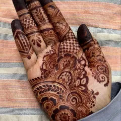 A rare design on my own right hand. This piece focuses on a dense cluster of floral and paisley patterns on the palm, with detailed work on the fingers.