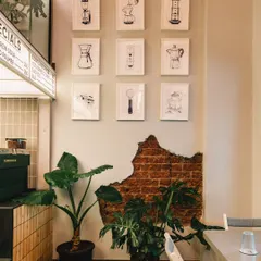 Details make the brand. At Stand By Coffee, I photographed this gallery wall of coffee-making illustrations next to the exposed brick, highlighting the cafe's passion for coffee culture and its rustic-modern aesthetic.