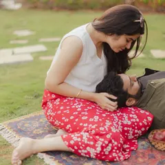 A tender moment during a romantic picnic setup. The groom-to-be rests in his partner's lap, a perfect picture of comfort and intimacy.
