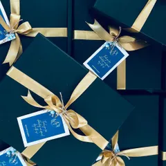 Elegant black gift boxes for wedding favors, finished with a luxurious gold satin ribbon and a personalized "Thank You" tag. A classic and sophisticated choice.