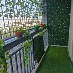 This balcony combines the best of both worlds. I installed an artificial grass floor and a green wall panel, and the client added their own touch with a mix of real and artificial potted plants along the railing.