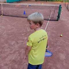 A young player in his Tennis by ActiveAce shirt, ready for action on the mini court. We build confidence from the very first lesson.