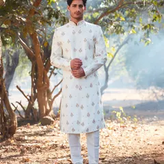 An elegant off-white sherwani with delicate, spaced-out embroidery. This outfit is all about understated sophistication, perfect for a daytime wedding or an intimate ceremony. The clean lines and subtle details ensure you look sharp and timeless.