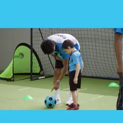 Our coach gives a young player a pointer on where to kick the ball. We use one on one instruction to ensure every child understands the basics of the game, building their skills and confidence with each tap of the ball.