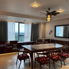 The dining area in the Embassy Lake Terraces project is both formal and inviting. We used a solid wood dining table and chairs with rich red patterned upholstery, complemented by custom cabinetry and large windows that fill the space with light.