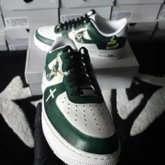 A front-facing shot of the Jägermeister-themed AF1s. This angle highlights the clean lines and detailed artwork on the front and side of the shoe, set against a background of fresh sneaker boxes.