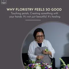 The simple, healing act of working with your hands. A student smiles as she puts the finishing touches on her arrangement, showcasing the joy that comes from creating something beautiful.