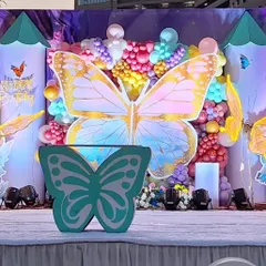 A close-up of our custom-fabricated props for a butterfly-themed birthday. This photo highlights the detailed butterfly-shaped table and the large, golden butterfly backdrop, both made in our workshop.
