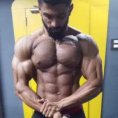 Capturing the gains in the gym mirror. This pose emphasizes chest striations and shoulder development, key components of a balanced, aesthetic physique.