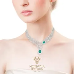 A graceful necklace featuring leaf-shaped diamond clusters accented with pear-shaped emerald drops. A beautiful fusion of diamonds and coloured gemstones.