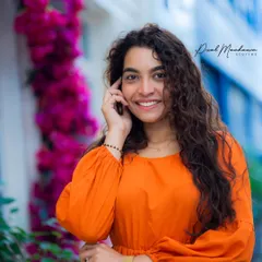 A great portrait is about finding the perfect frame. The combination of the vibrant orange dress, the elegant white doorway, and the cascade of pink flowers created a stunning, high-contrast urban look.