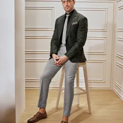A business suit should have character. This checked blazer in green and grey, paired with tailored trousers and fine leather shoes, is a perfect blend of classic power and modern style for the discerning professional.
