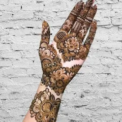 A full and festive design for the back of the hand, with intricate floral and paisley work.