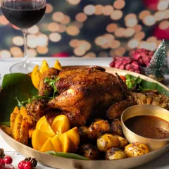 A magnificent whole roasted turkey, the centerpiece of a Christmas feast, styled with oranges and fresh herbs.