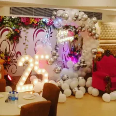 Banquet hall mein 25th anniversary function ke liye yeh ek complete setup hai. Ismein silver chrome balloons ka arch, '25' number ke light letters, aur 'Happy Anniversary' ka neon sign hai.