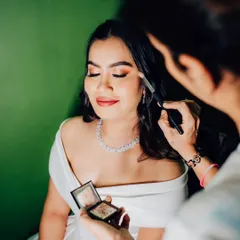 A moment of focus while applying eyeshadow. It's all about blending and building color to create the perfect shape and intensity for the bride's eyes.