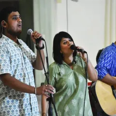 Volunteers sing during a satsang. Volunteering with us is not just about work; it's about finding joy, community, and a deeper connection to oneself through service and celebration.