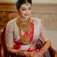 A regal South Indian bride looking absolutely timeless. Her intricate mehendi adds the final touch of tradition to her beautiful red and white silk saree and temple jewelry.