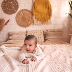 A beautiful shot of a baby enjoying tummy time in our warm and inviting bohemian-style studio.