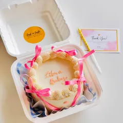 A cute "Libra Baby" bento cake. This mini cake features vintage-style piping and pink ribbons, all neatly packed in a personal-sized box.