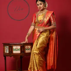 A full-length portrait of a model in a stunning red and gold Kanjeevaram saree. The makeup is classic bridal glam, with bold eyes and lips, paired with heavy temple jewellery for a majestic look.