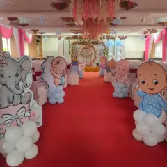 A view from the entrance of the naming ceremony hall, showing the pathway decorated with cute baby and elephant cutouts on balloon bases. This creates a wonderful, themed welcome for guests.