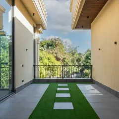 A simple yet elegant balcony design. The combination of artificial grass and clean white stone pavers creates a graphic, modern look that connects the indoor space with the outdoors.