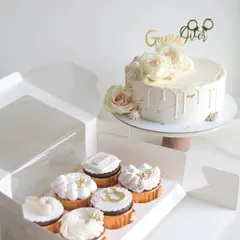 This elegant white chocolate drip cake with fresh roses was created for a bachelorette party. It was paired with custom-themed cupcakes, making for a beautiful and delicious dessert spread for the bride-to-be.