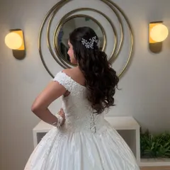 A side view of the bride's romantic hairstyle, showing the beautiful curls and the delicate placement of the hair accessory.
